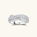 Sterling silver crossover ring with pavé-set moissanite stones creating an elegant infinity design on neutral background